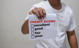 young man showing a signboard with different ranges of the credit score - excellent, good, fair, and poor photo