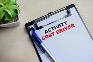 Concept of Activity cost driver write on clipboard isolated on Wooden Table. photo
