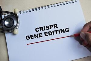 Concept of Crispr gene editing write on book isolated on Wooden Table. photo