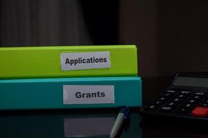 folders with the label Applications and grants. Business management concept photo