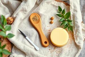 Natural skincare soap bar with wooden spoon and green leaves on fabric photo
