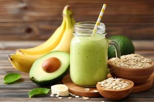 Fresh green smoothie with banana, avocado and rolled oats on rustic wooden table photo