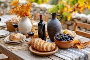 Autumn table setting with wine, bread, grapes, and rustic decor photo