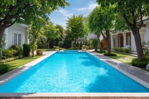 Inviting rectangular swimming pool surrounded by lush green trees and modern villas photo