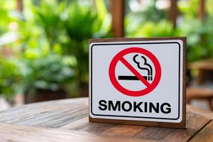 No smoking sign stands on table in blurred green garden background photo