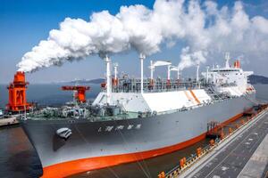 Large lng tanker moored at the loading dock is emitting white smoke photo