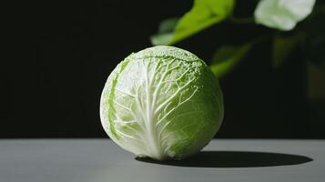 A green cabbage is sitting on a table photo