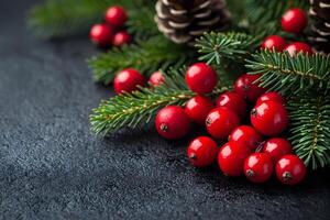 Festive Christmas Decoration with Red Berries and Pine Cones on Dark Background photo
