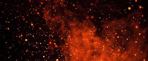 The vibrant explosion of fiery particles against a dark background. photo