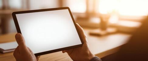 The modern tablet held in hands against a bright workspace background. photo