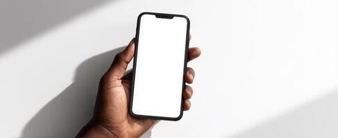 The smartphone held in a hand showcasing a blank screen for customization. photo