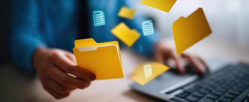 The Digital Interaction with Floating Yellow Folders and Laptop Keyboard photo