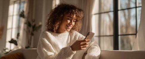 A woman sitting on a couch looking at her phone photo