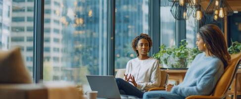 The women engaged in a meaningful conversation in a modern office setting. photo