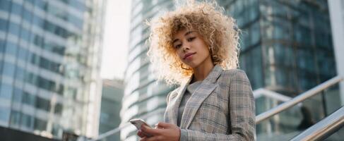 The professional woman using her smartphone in a modern urban environment. photo
