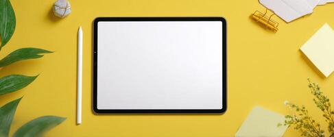 The minimalist tablet on a vibrant yellow workspace for creative ideas. photo
