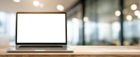 The modern laptop on a wooden desk in a bright workspace setting. photo