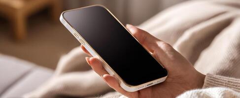 The modern smartphone held in a cozy, inviting environment. photo