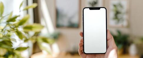 The modern smartphone held in hand against a stylish interior backdrop photo