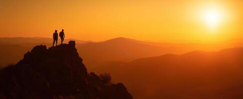 The hikers enjoying a breathtaking sunset view on the mountain peak. photo