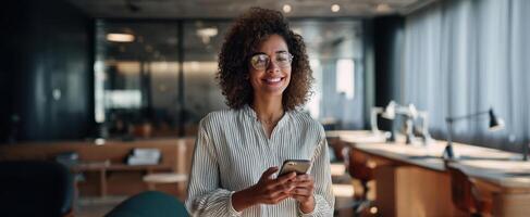 The smiling woman using a smartphone in a modern office environment. photo
