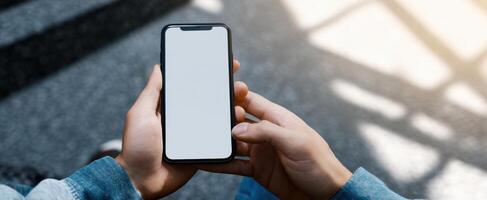 The smartphone displaying a blank screen held by hands in a casual setting. photo