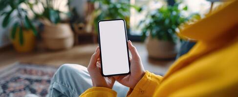 The smartphone held by a person in a cozy indoor setting photo