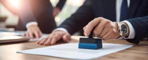 The businessman using a stamp on important legal documents in an office setting. photo