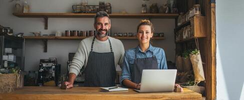 A man and woman standing in front of a laptop photo