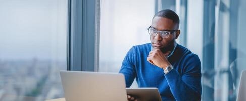 The thoughtful businessman engaged with technology in a modern office setting. photo