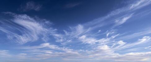The serene panorama of wispy clouds against a bright blue sky. photo