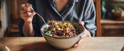 The person enjoying a vibrant and nutritious bowl of healthy grains and vegetables. photo