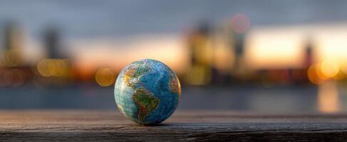 The globe resting on a wooden surface with a city backdrop at sunset. photo