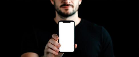 The man holding a smartphone with a blank screen in a dark setting. photo