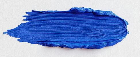 The vibrant blue paint stroke on textured canvas surface photo