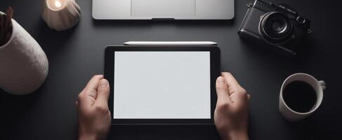 The tablet in hands showcasing a modern and minimalist workspace setup. photo