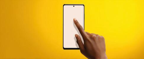 The smartphone interacting with a user's hand against a vibrant yellow background. photo