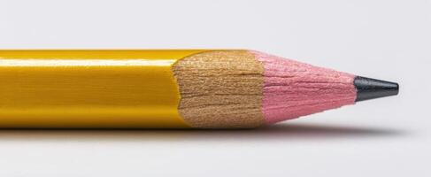 The finely sharpened pink pencil with yellow casing on a clean background photo