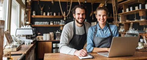 The smiling couple managing a modern cafe workspace with a laptop. photo
