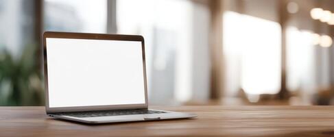 The sleek laptop positioned on a wooden desk in a modern workspace. photo