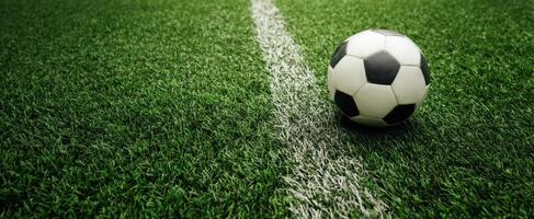 The soccer ball resting on a vibrant green grass field. photo