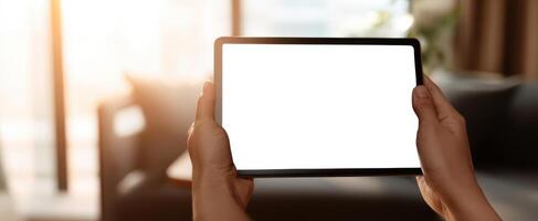 The modern tablet held by hands in a cozy home setting with natural light. photo