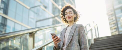 The confident woman smiling while walking up stairs in a modern city. photo