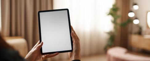 The sleek tablet held in hands against a modern home interior backdrop. photo