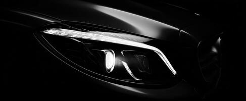 The elegant design of a modern automobile headlight illuminated in darkness. photo