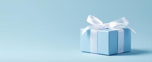 The beautiful blue gift box tied with a white ribbon on a soft background. photo