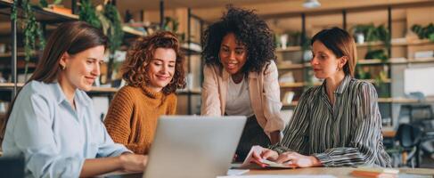 The women collaborating over a laptop in a modern office environment. photo