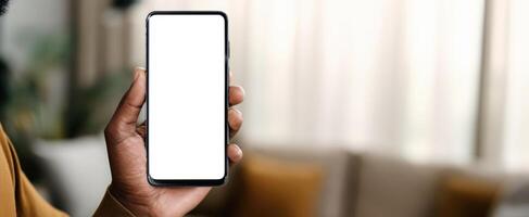 The smartphone held by a person in a cozy indoor setting with soft lighting. photo