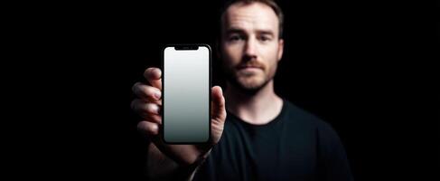 The modern man holding a smartphone in a dark and stylish setting. photo