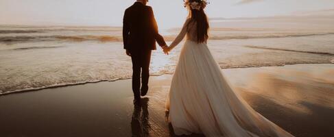 The romantic couple walking hand in hand along the serene beach at sunset. photo